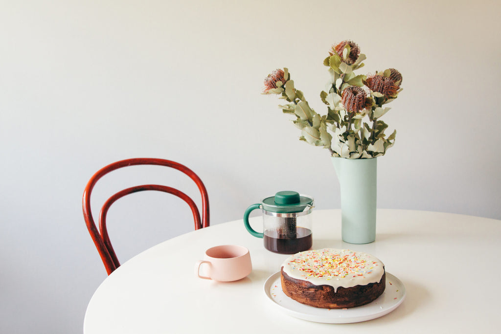 Orange and cannellini bean cake with icing and sprinkles on a table for Lunch Lady Magazine