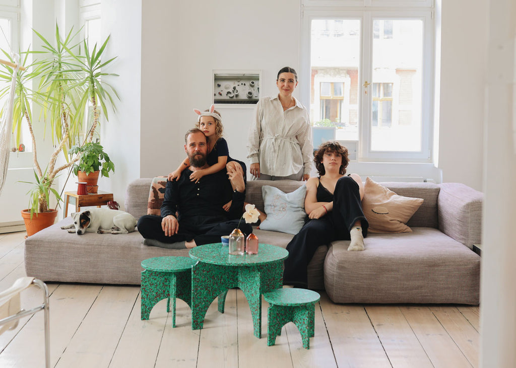The family behind MiNiMONO furniture sitting on a couch in their Berlin apartment