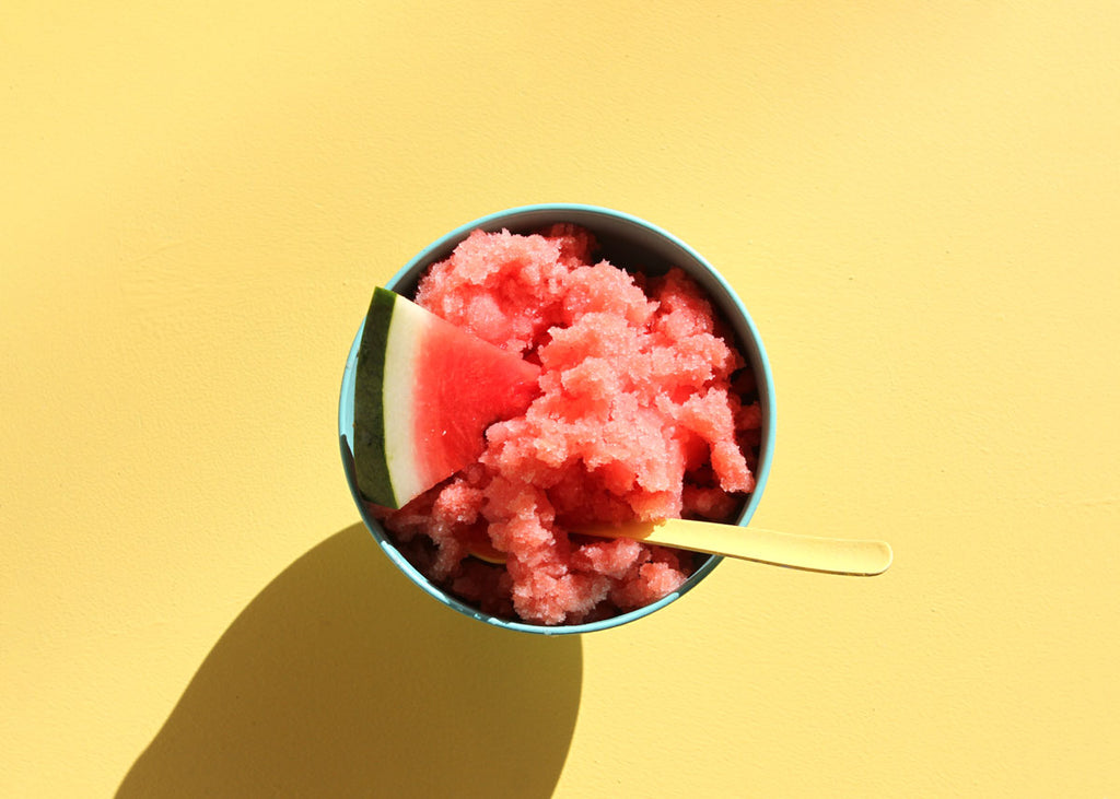 a bowl of watermelon sorbet with a small slice of watermelon in and a spoon