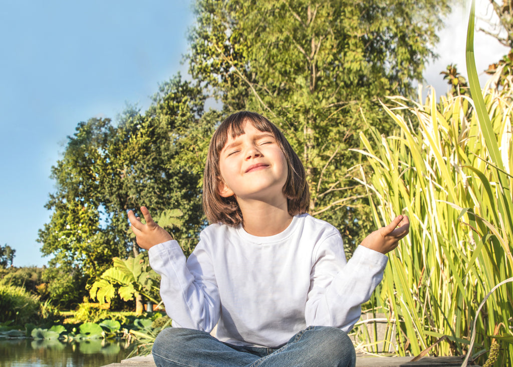 a girl meditating for mindfulness for kids for lunch lady magazine